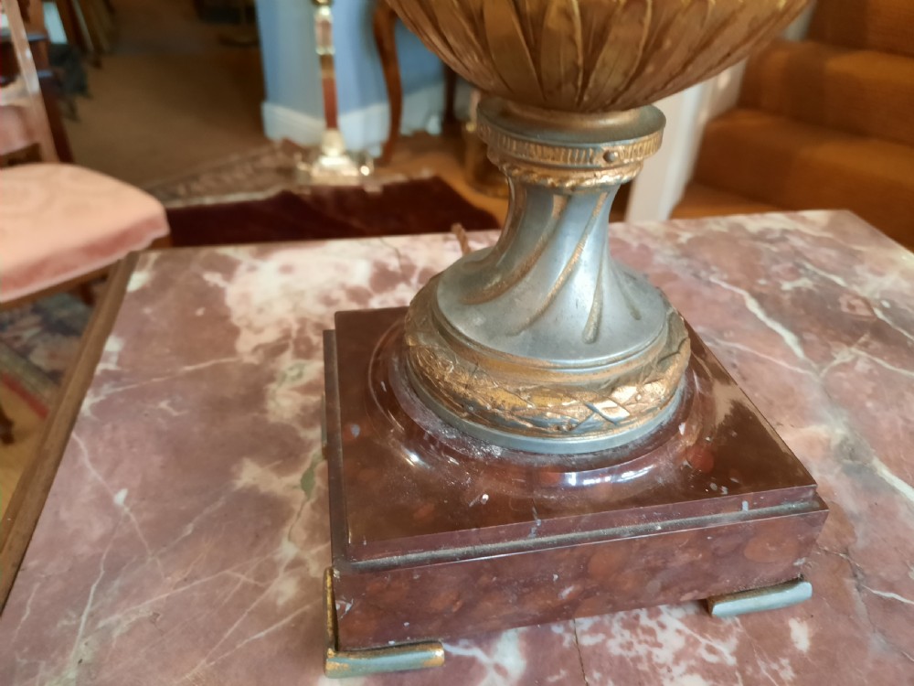 A 19th-century gilt bronze classical urn mounted as a table lamp on a square marble base with a fringed fabric shade. View V