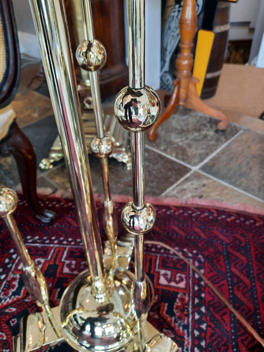 An early 20th-century Art Nouveau brass standard lamp featuring openwork base detailing and a patterned terracotta lampshade with fringe and tassels. View V