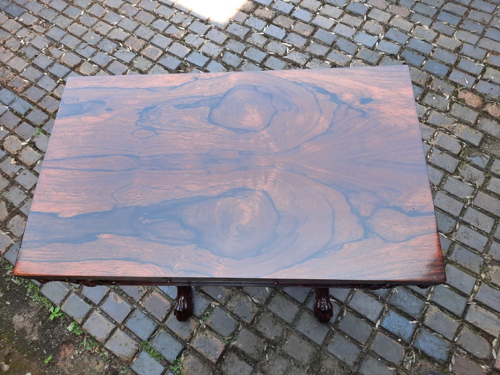 A 19th-century rosewood card table with a fold-over rectangular top, carved scroll apron, turned supports, and carved claw feet. View VI