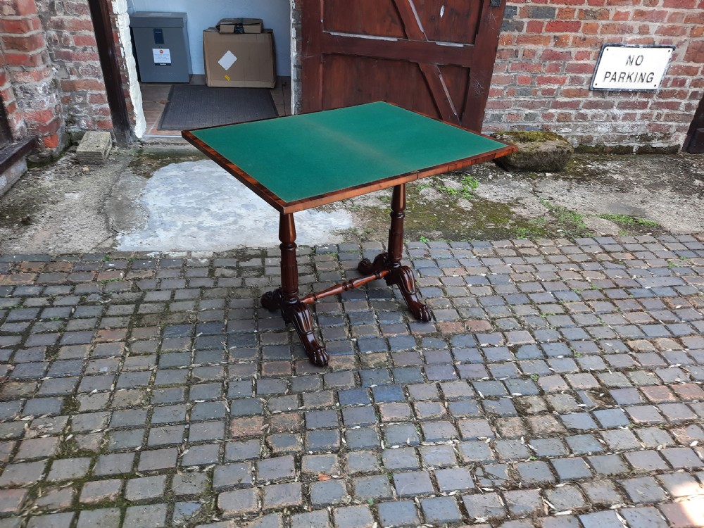 A 19th-century rosewood card table with a fold-over rectangular top, carved scroll apron, turned supports, and carved claw feet. View VIII