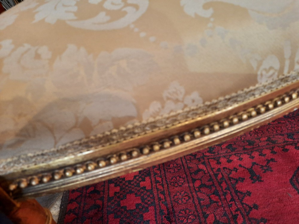 A pair of Victorian giltwood salon chairs featuring fluted legs and pale cream damask upholstery. View III