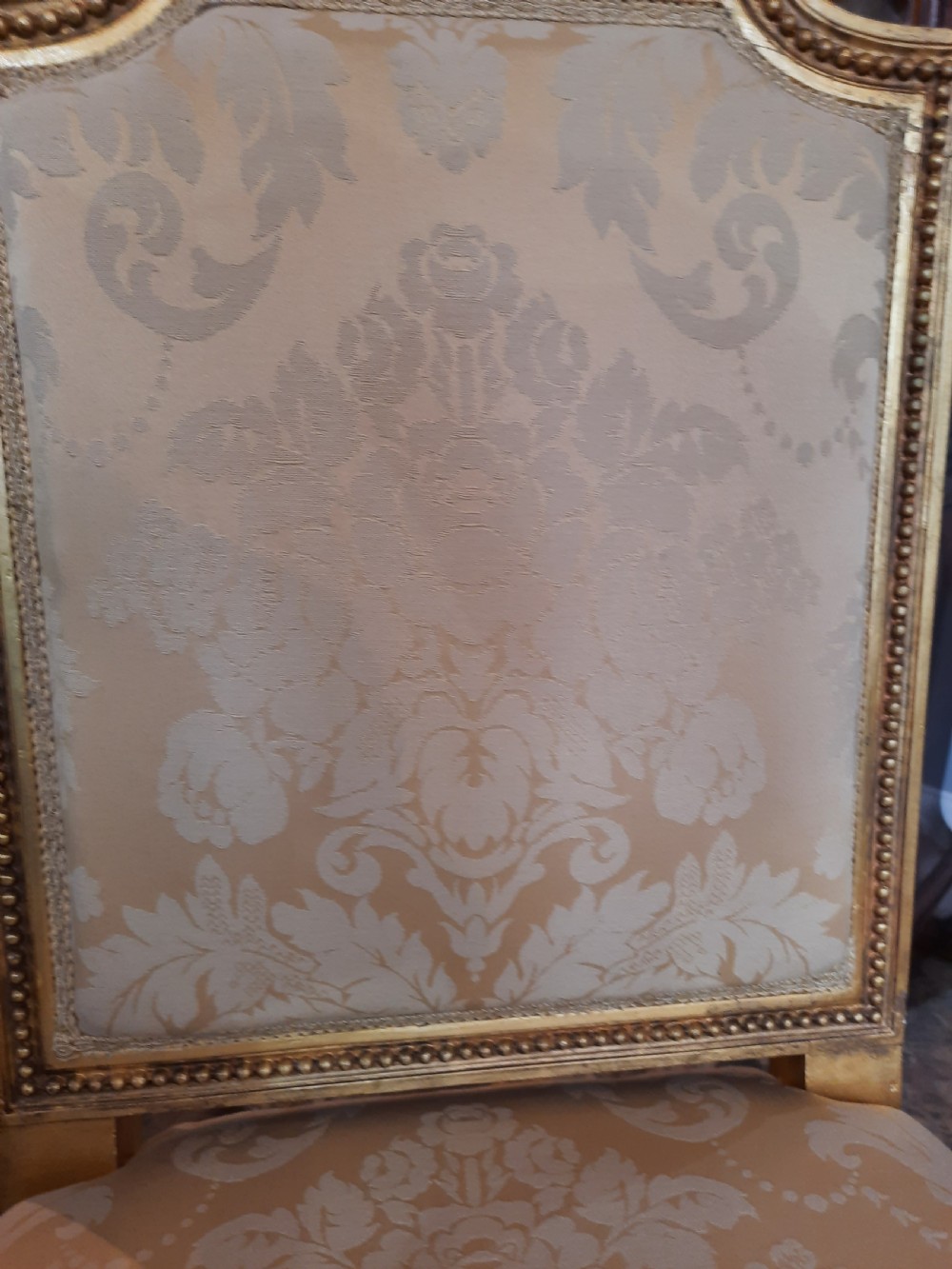 A pair of Victorian giltwood salon chairs featuring fluted legs and pale cream damask upholstery. View IV