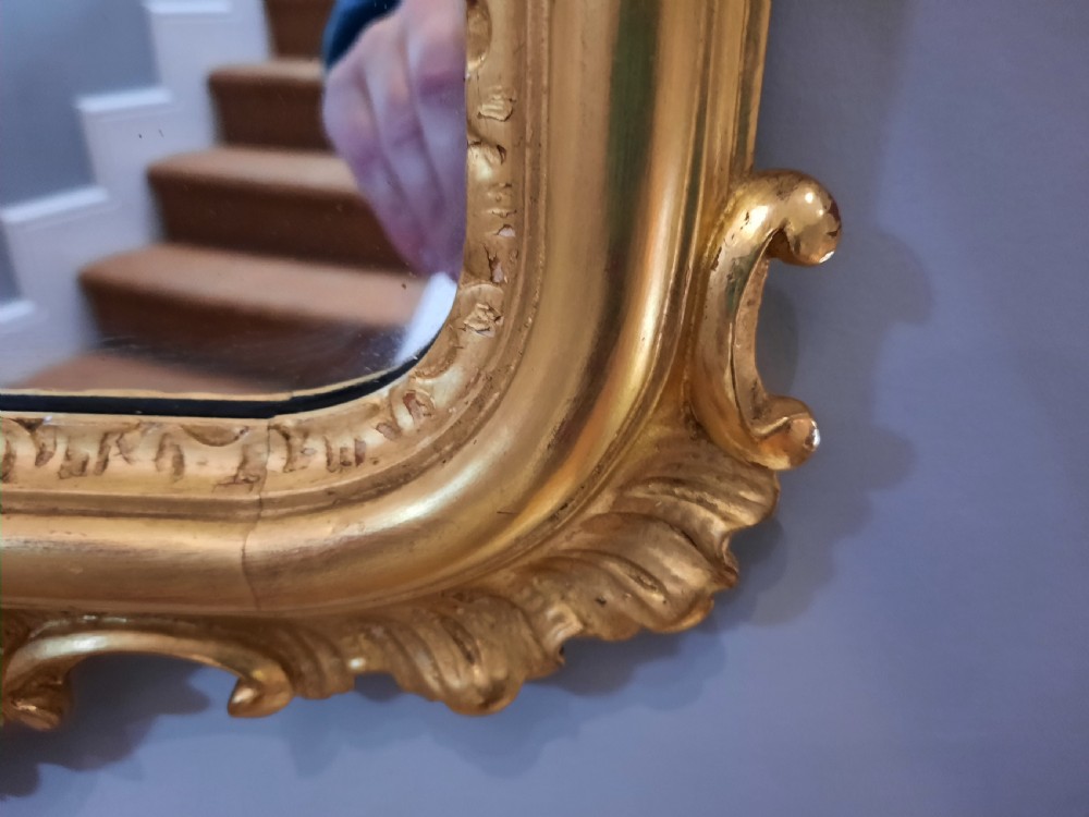 A tall arched late Victorian pier mirror featuring an ornate gold giltwood frame with carved foliate scrolls and a top cresting finial. View IV