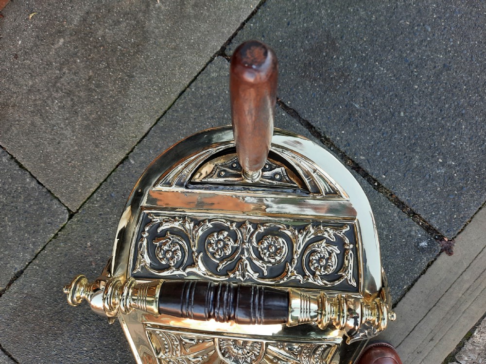 An antique brass coal purdonium in the Adam style, featuring intricate repousse classical motifs, a pedestal base, carrying handle, and attached shovel. View III