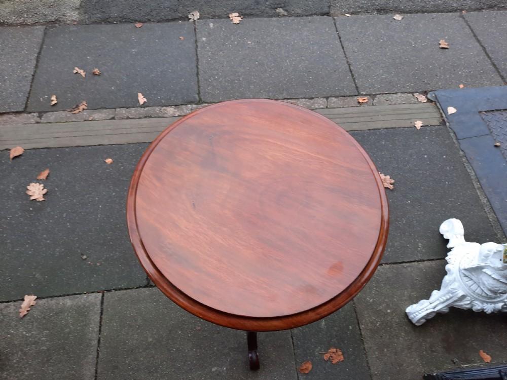 A Victorian mahogany occasional table featuring a circular top, turned central pedestal stem, and three curved tripod feet. View II