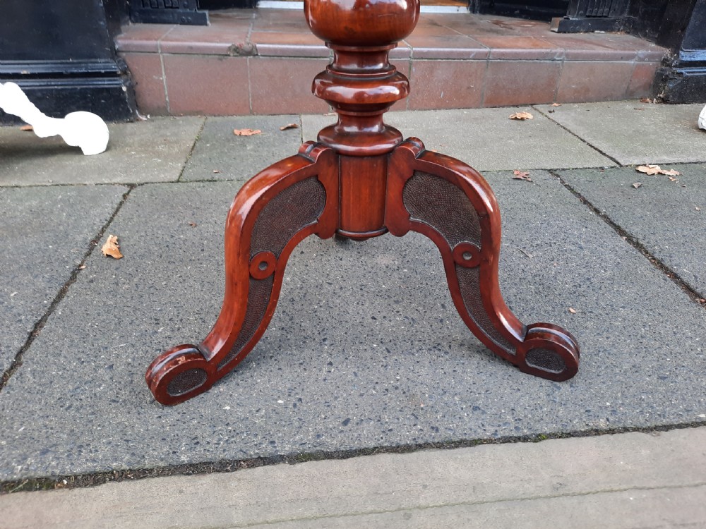 A Victorian mahogany occasional table featuring a circular top, turned central pedestal stem, and three curved tripod feet. View V