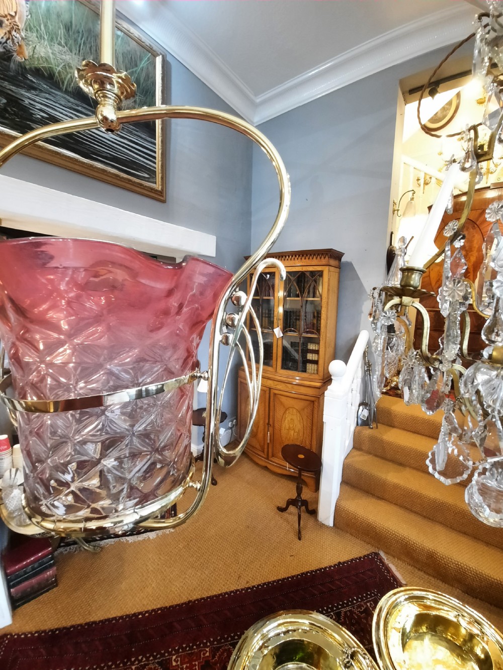 An Art Nouveau brass pendant light frame housing a ruffled cranberry glass shade with a moulded diamond pattern. View II