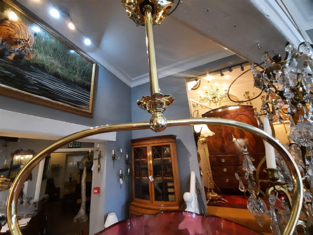 An Art Nouveau brass pendant light frame housing a ruffled cranberry glass shade with a moulded diamond pattern. View III