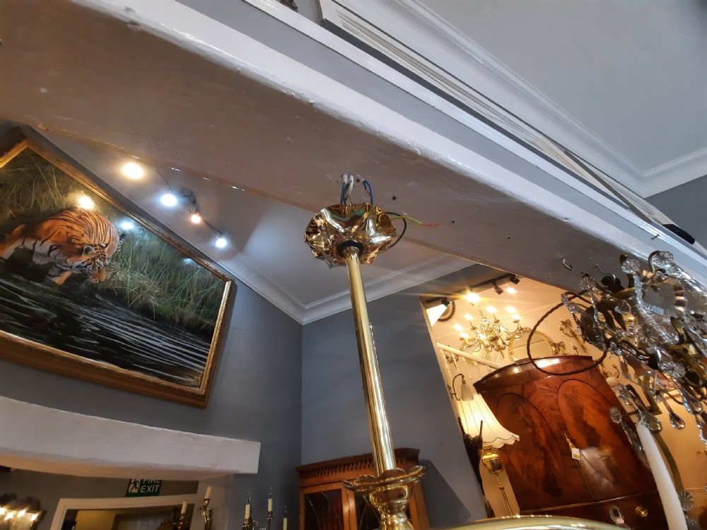 An Art Nouveau brass pendant light frame housing a ruffled cranberry glass shade with a moulded diamond pattern. View IV