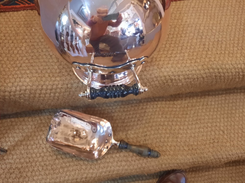A polished copper Georgian coal helmet scuttle with turned wooden handles and a pedestal base. View VII