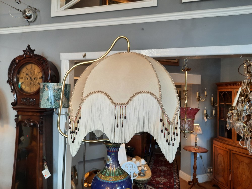 A 1920s painted cream wooden standard lamp featuring a central blue decorated ceramic vase, a gooseneck brass arm, and a fabric lampshade with beaded fringe. View II