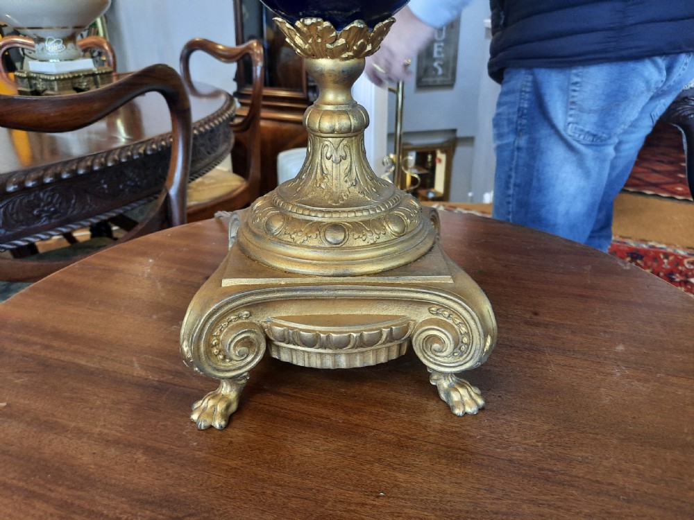 A pair of late nineteenth-century cobalt blue glass ewer lamps with ornate gilt bronze mounts and cream fabric shades featuring fringe and bead tassels. View II