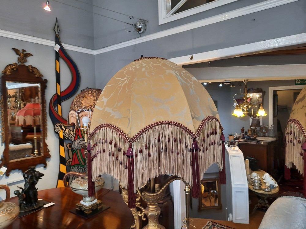 A pair of late nineteenth-century cobalt blue glass ewer lamps with ornate gilt bronze mounts and cream fabric shades featuring fringe and bead tassels. View VII