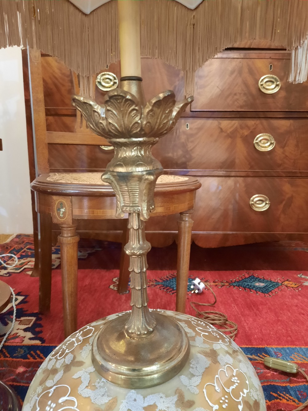 A pair of late Victorian table lamps featuring ornate gilt brass stems, painted glass baluster bases, and cream silk shades with fringe tassels. View III