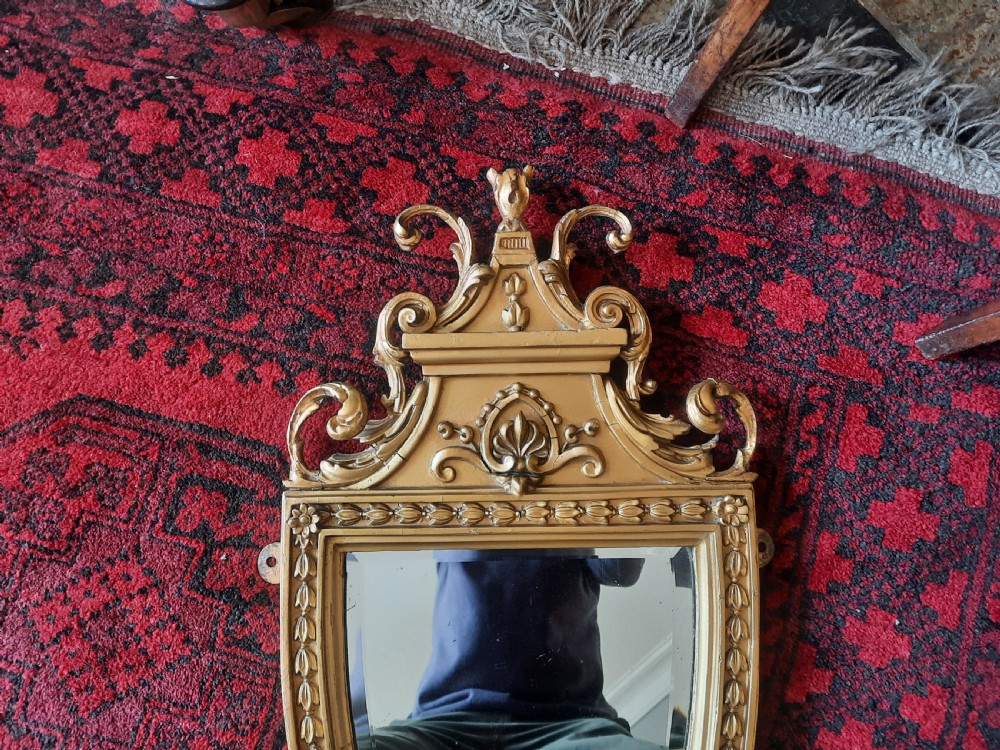 A Victorian Neoclassical giltwood wall mirror featuring a shield-shaped frame, scroll carved cresting, an integrated lower shelf, and a pendant drop finial. View III
