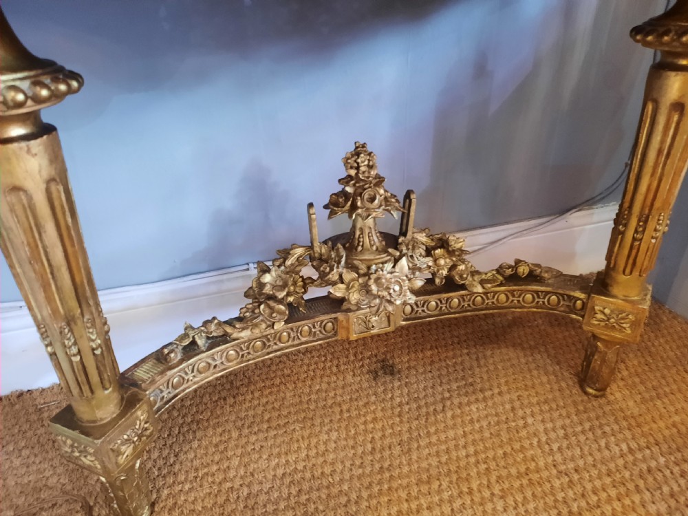 An early 19th-century semicircular giltwood console table featuring a white marble top, carved classical medallion, decorative swags, and fluted legs. View IV