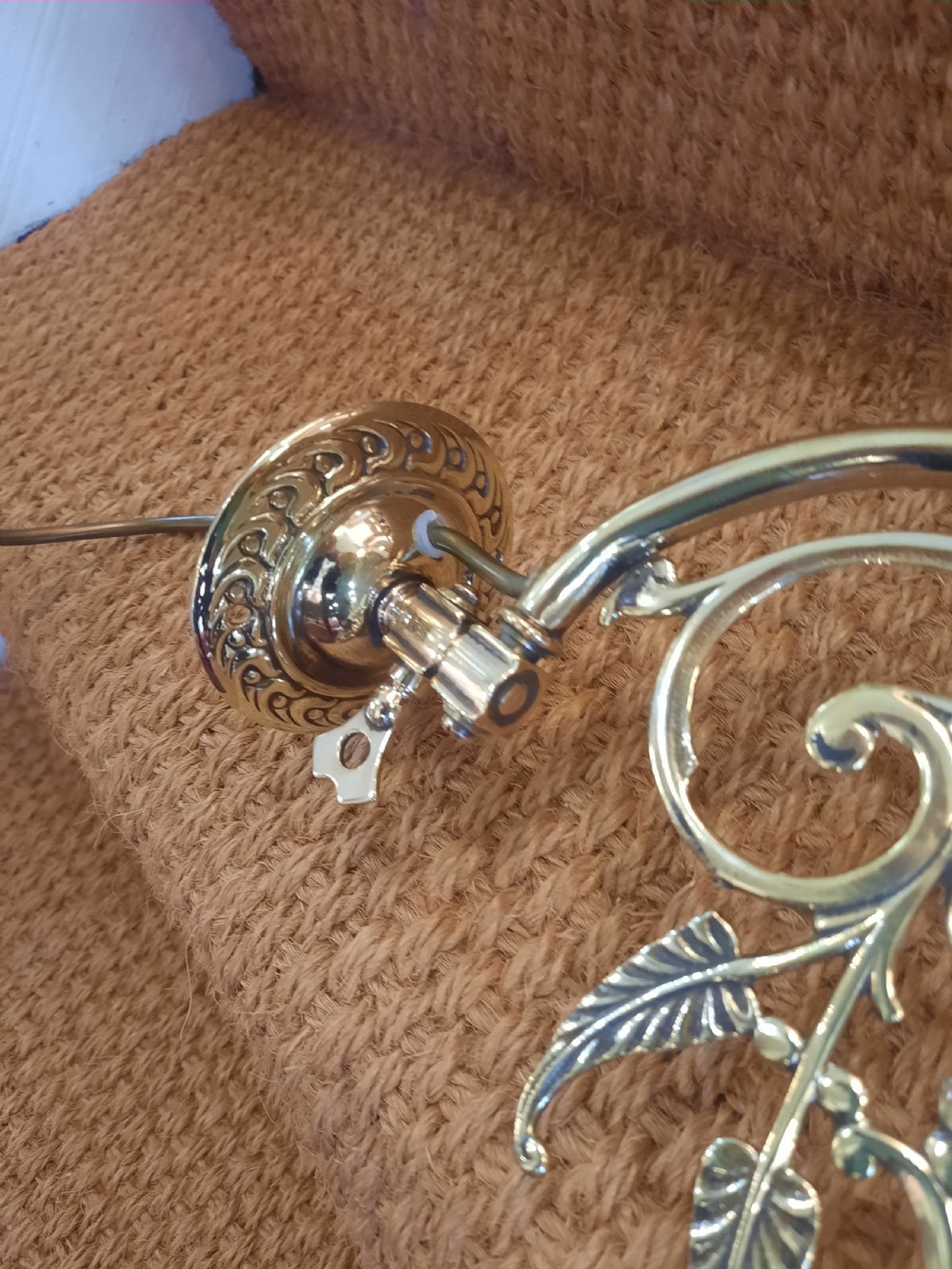A pair of Art Nouveau brass wall lights featuring foliate scrolled arms and fluted cranberry glass shades. View III