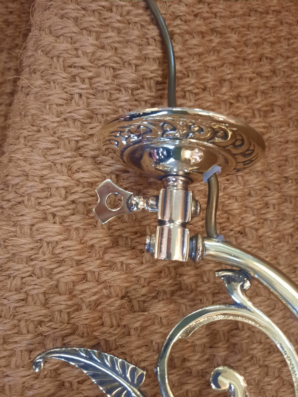 A pair of Art Nouveau brass wall lights featuring foliate scrolled arms and fluted cranberry glass shades. View IV