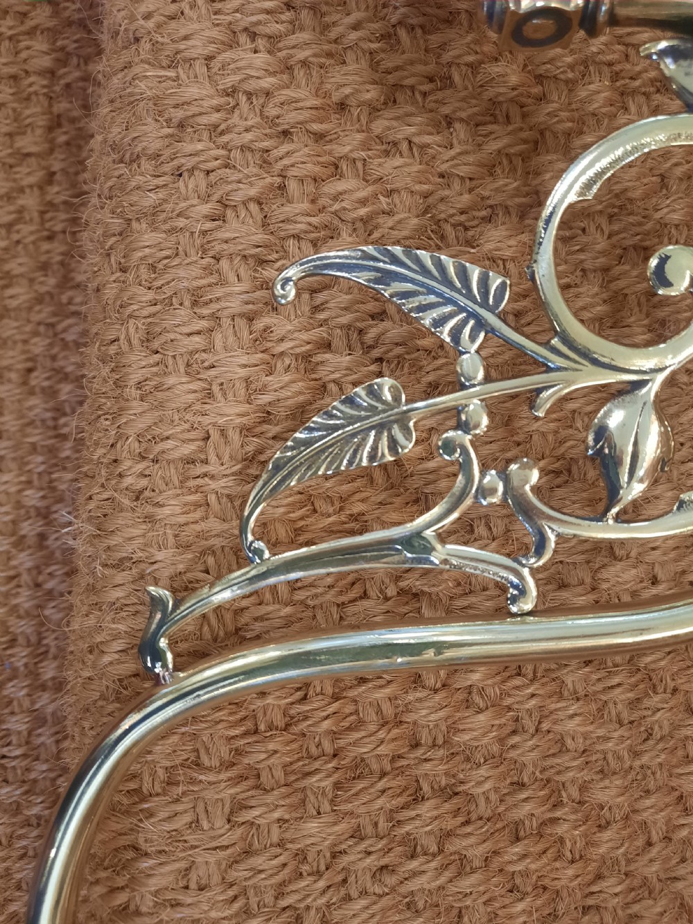 A pair of Art Nouveau brass wall lights featuring foliate scrolled arms and fluted cranberry glass shades. View V