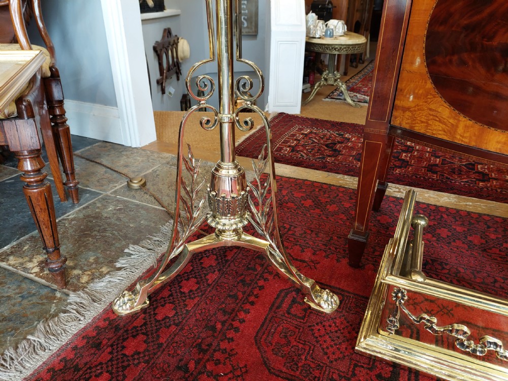 A late Victorian brass and copper extending standard floor lamp featuring a scrolled tripod base and a cream fringed shade. View II