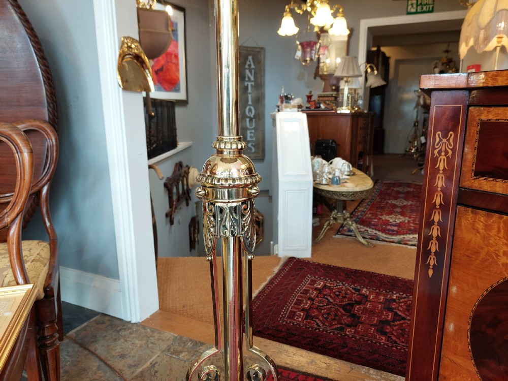 A late Victorian brass and copper extending standard floor lamp featuring a scrolled tripod base and a cream fringed shade. View III