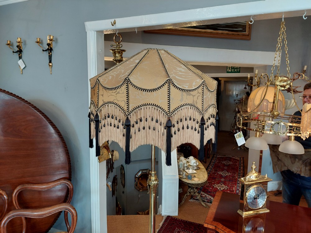 A late Victorian brass and copper extending standard floor lamp featuring a scrolled tripod base and a cream fringed shade. View VI