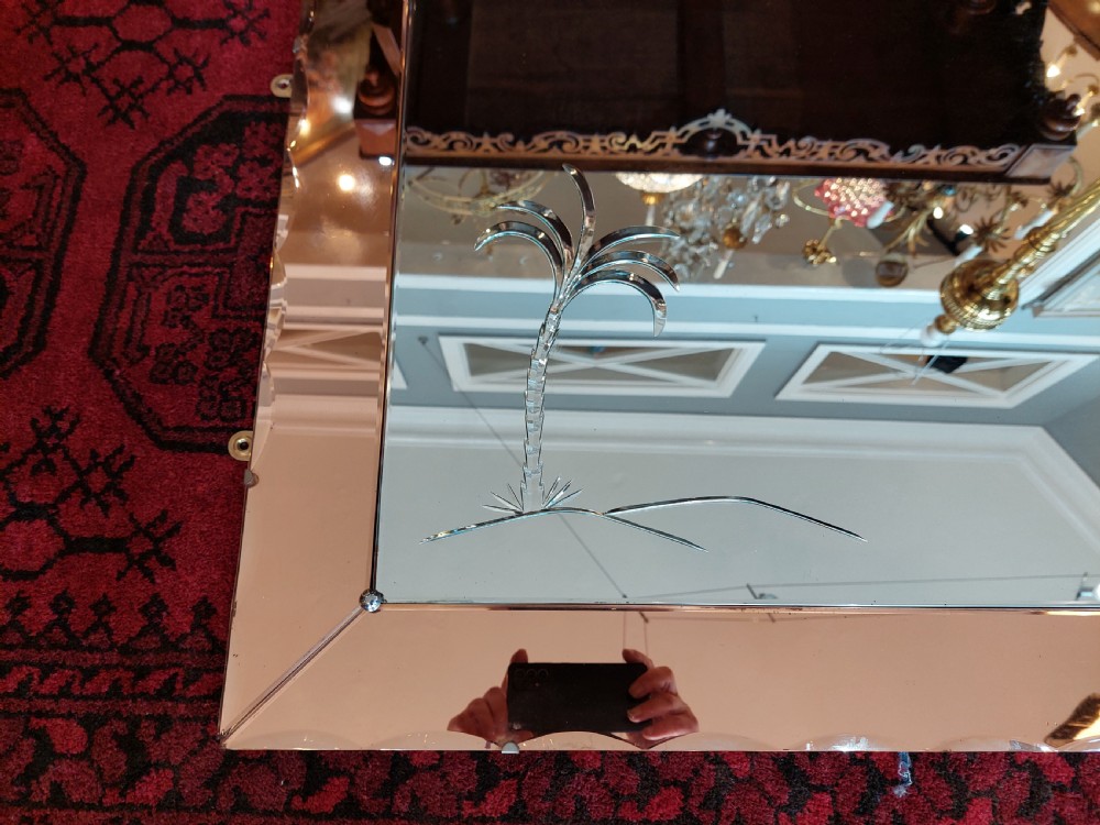 A rectangular Art Deco wall mirror featuring a peach-tinted glass border with scalloped outer edges and an etched palm tree design in the bottom corner. View II