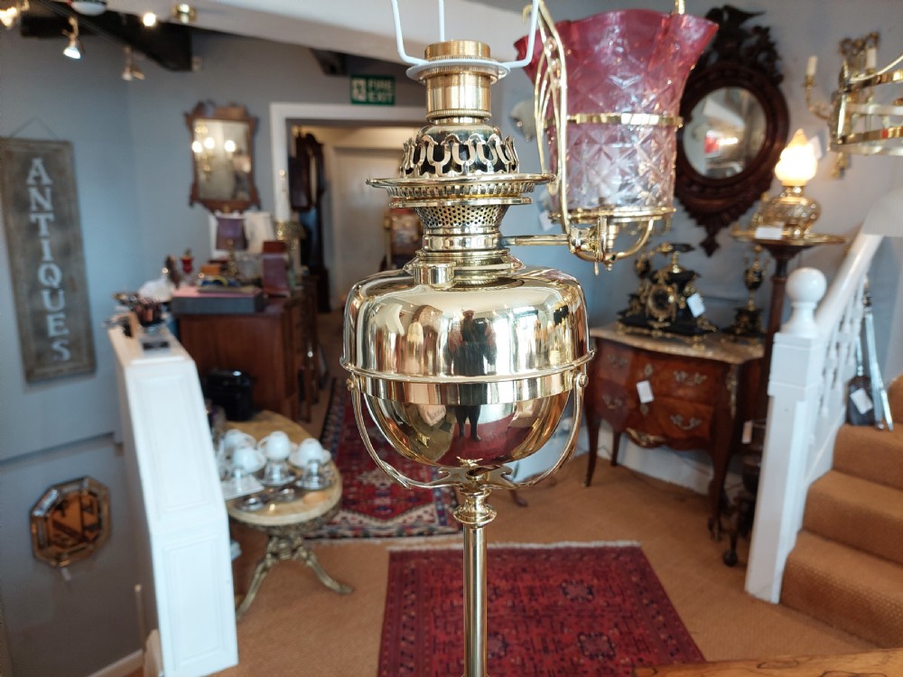 An Art Nouveau brass adjustable standard lamp with a tripod base, telescopic central stem, and a cream fringed fabric shade. View IV
