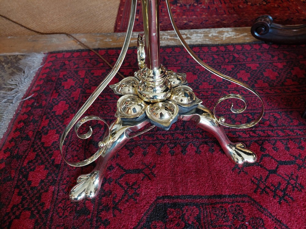 An Art Nouveau brass adjustable standard lamp with a tripod base, telescopic central stem, and a cream fringed fabric shade. View V