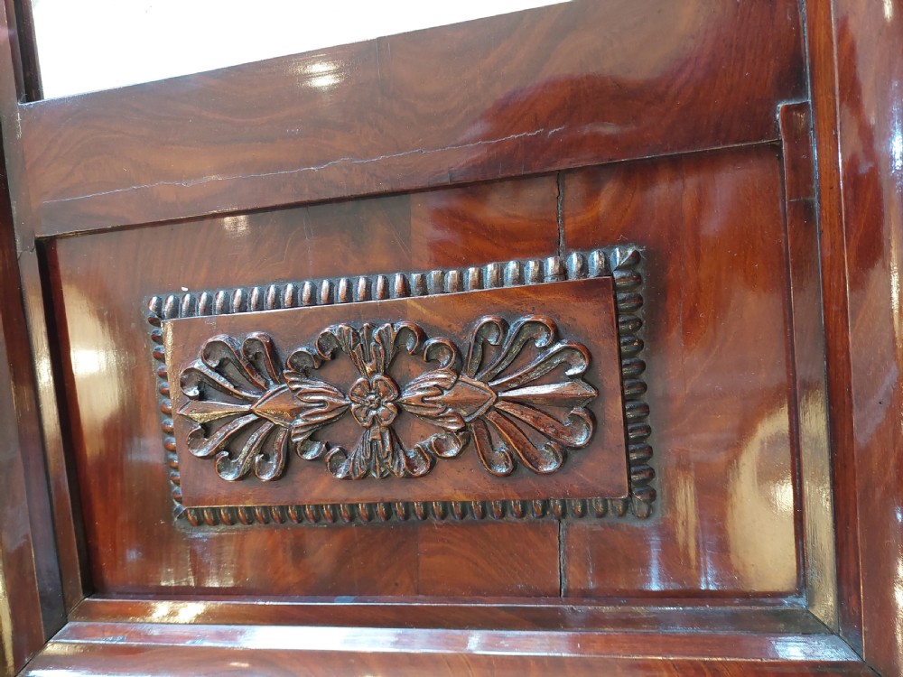 A tall early nineteenth-century Biedermeier mahogany pier mirror featuring a stepped top cornice, a carved floral frieze panel, and a rectangular glass plate. View II