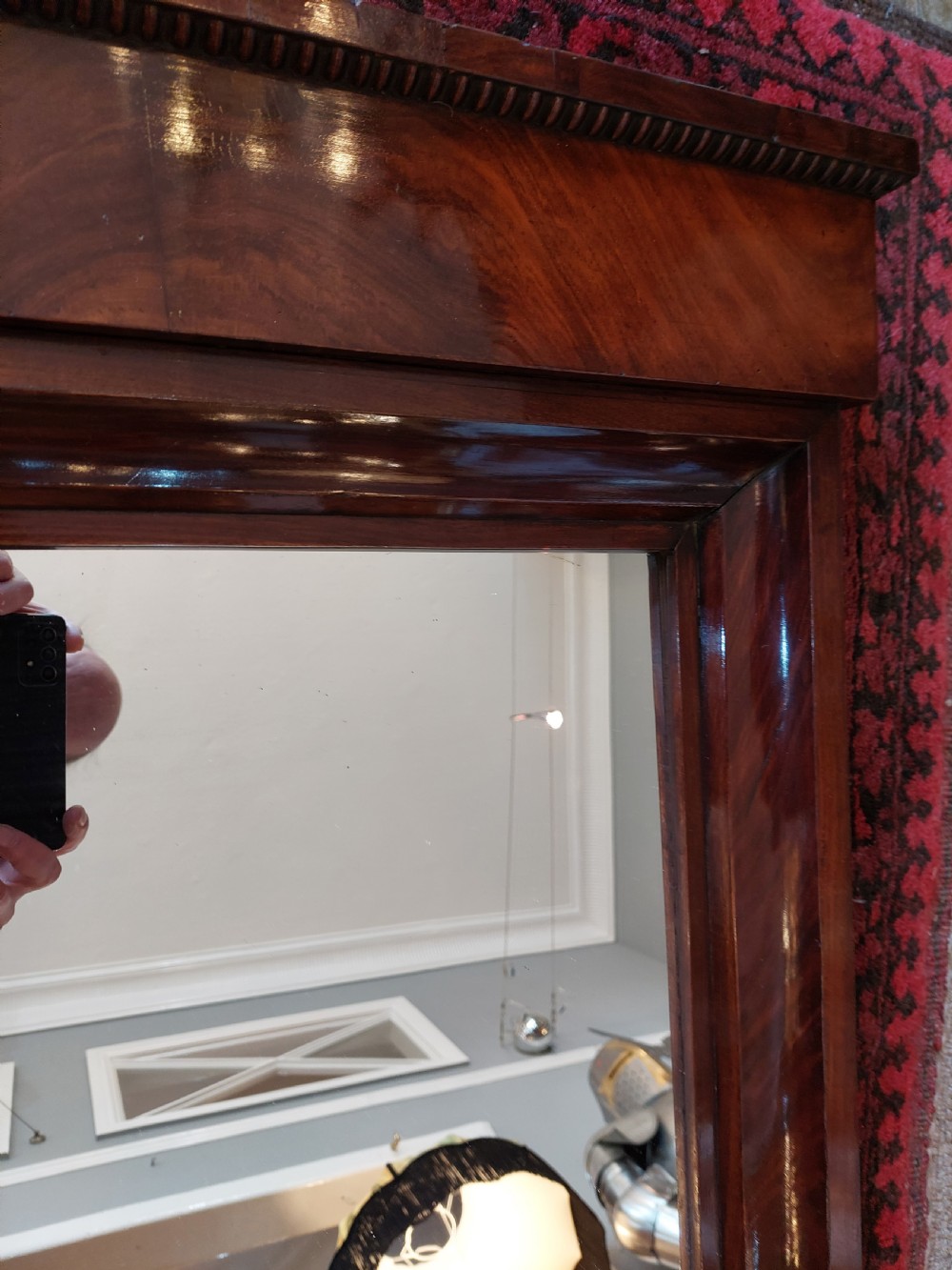A tall early nineteenth-century Biedermeier mahogany pier mirror featuring a stepped top cornice, a carved floral frieze panel, and a rectangular glass plate. View V
