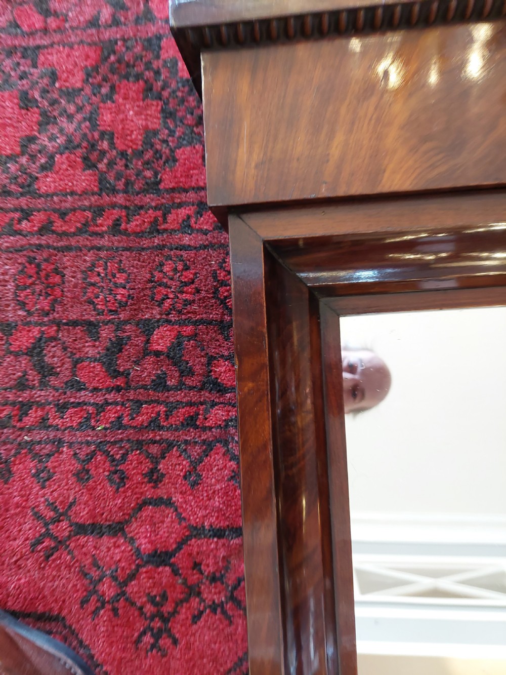 A tall early nineteenth-century Biedermeier mahogany pier mirror featuring a stepped top cornice, a carved floral frieze panel, and a rectangular glass plate. View VII