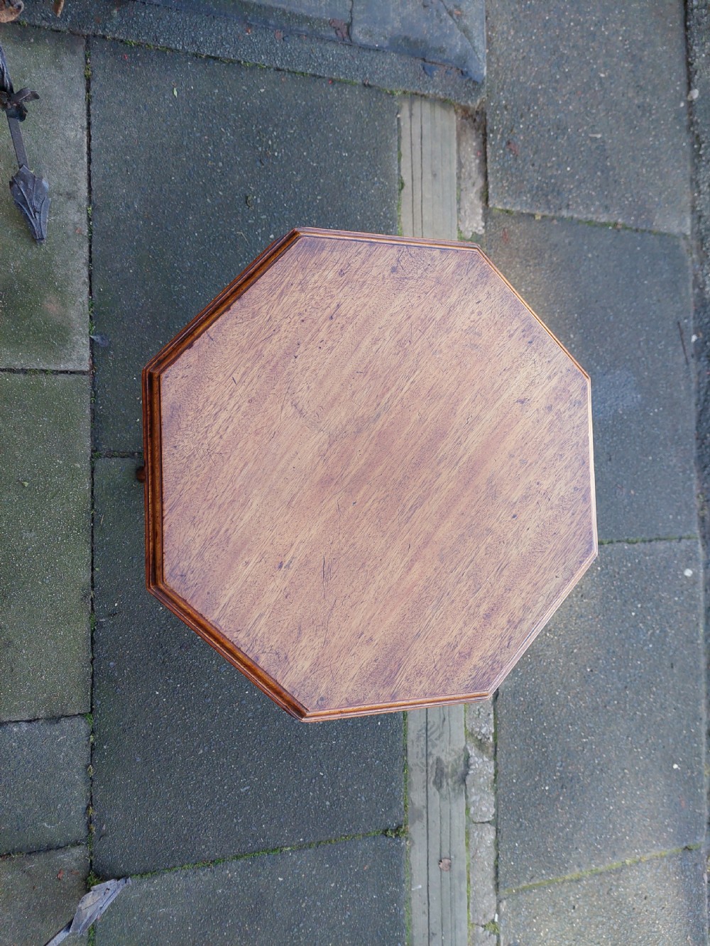 An antique Victorian Gothic mahogany tripod side table with an octagonal top, fluted central column, and three carved decorative legs. View II