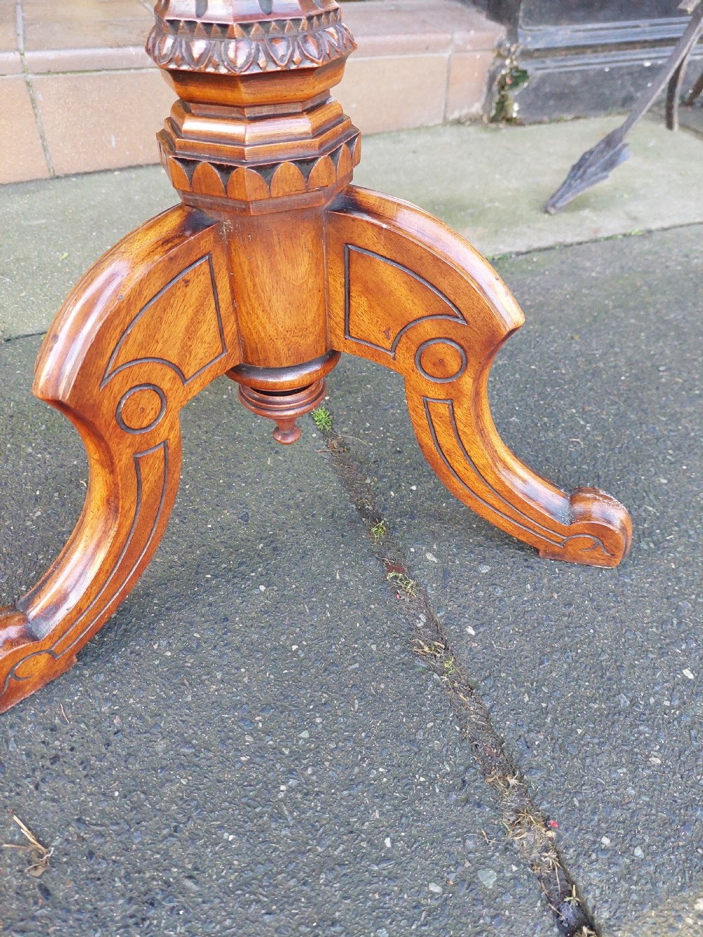 An antique Victorian Gothic mahogany tripod side table with an octagonal top, fluted central column, and three carved decorative legs. View III