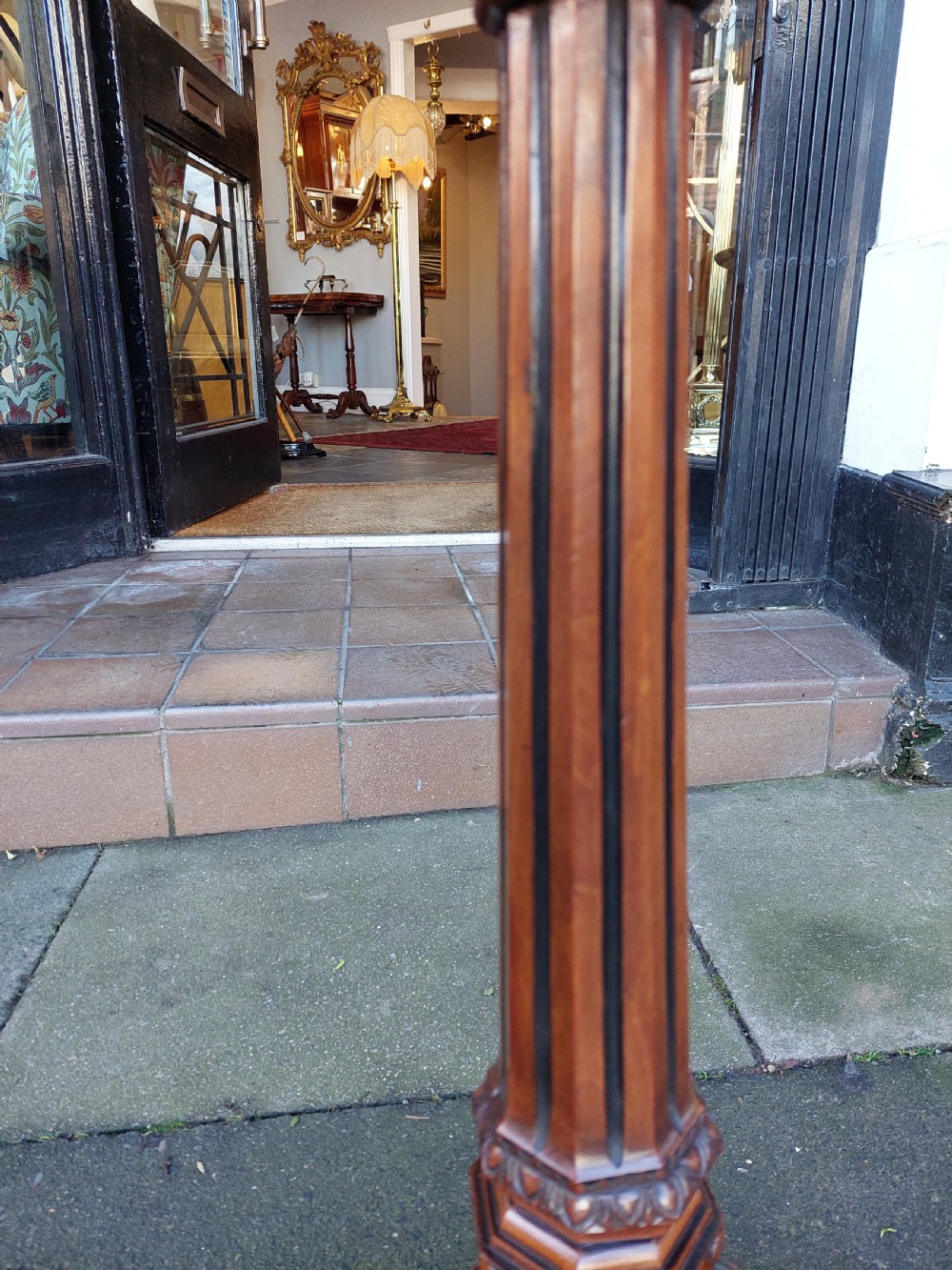 An antique Victorian Gothic mahogany tripod side table with an octagonal top, fluted central column, and three carved decorative legs. View V