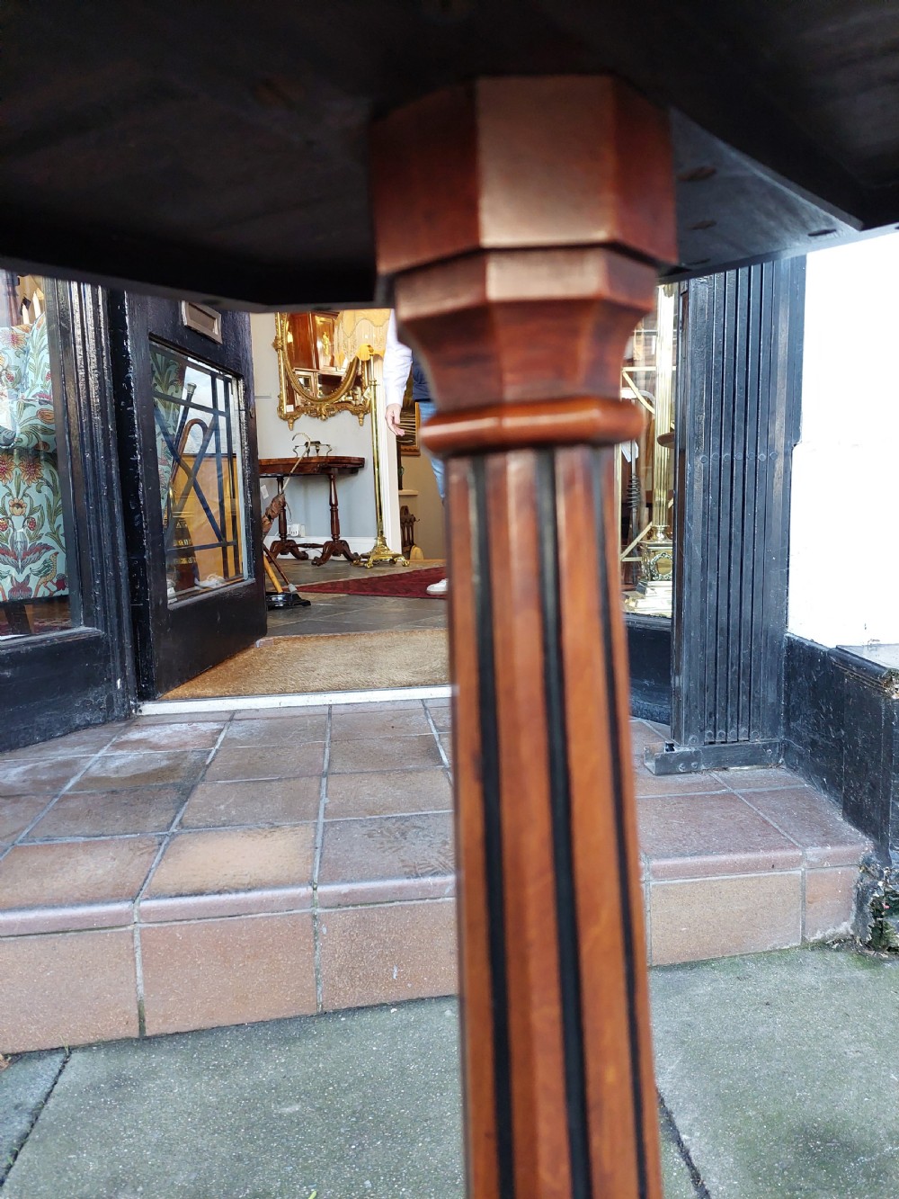 An antique Victorian Gothic mahogany tripod side table with an octagonal top, fluted central column, and three carved decorative legs. View VI