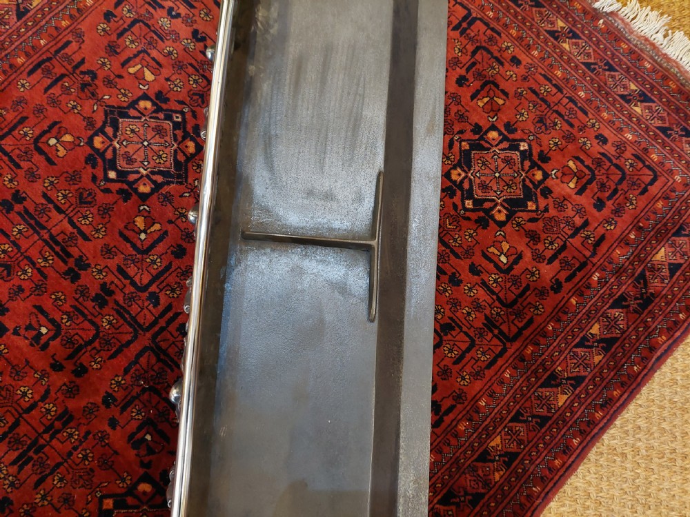 A 19th-century polished steel and iron fireplace fender featuring detailed openwork scroll motifs and shaped corner feet. View VII