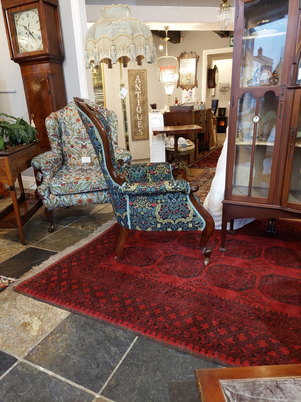 Victorian mahogany scroll frame armchair upholstered in a dark botanical floral fabric with a button-backed cushion and carved cabriole legs on castors. View VIII