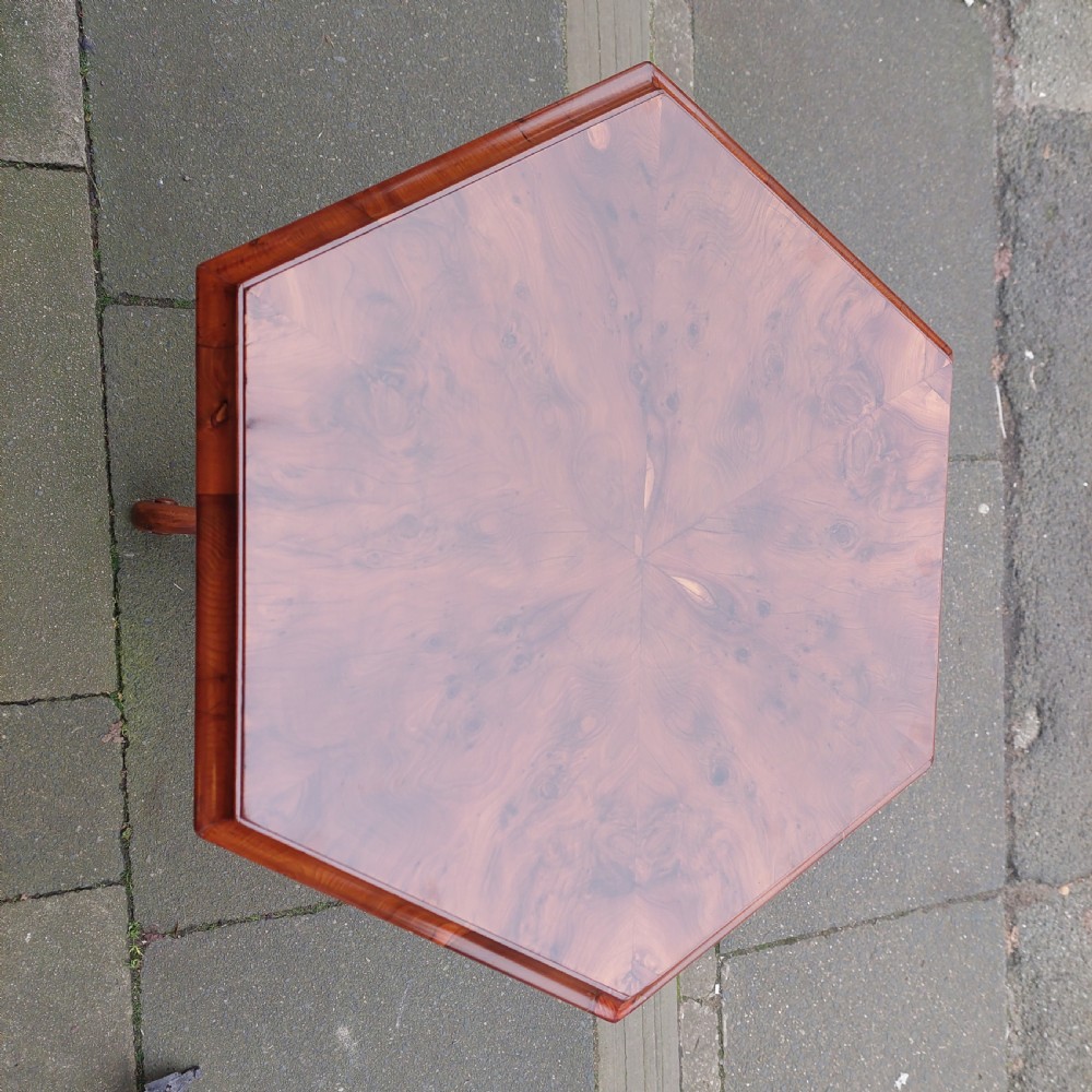 A 19th-century octagonal yew wood work table featuring a hinged top lid, a tapered central body, and carved tripod legs. View II