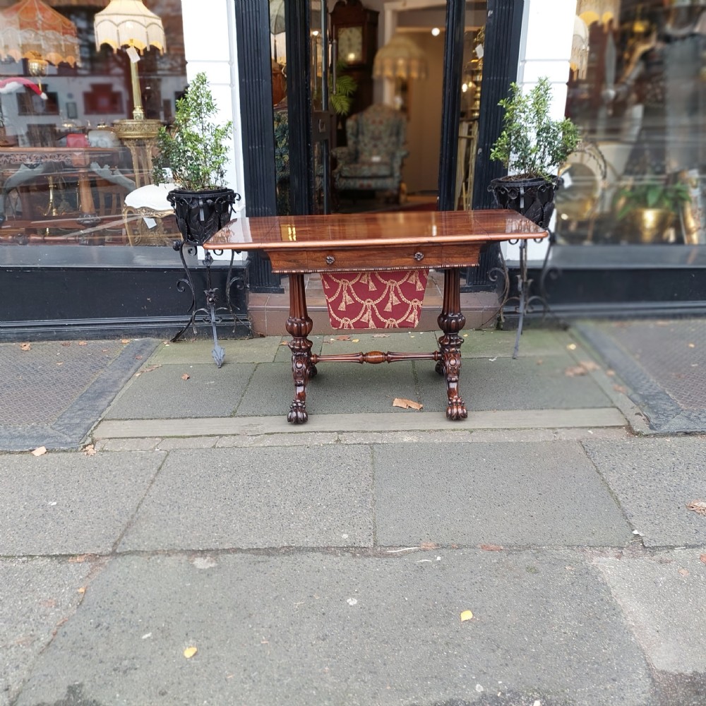 A Regency rosewood work table featuring drop leaves, a single frieze drawer, a red patterned fabric sewing well below, turned pedestal supports, and carved claw feet. View II