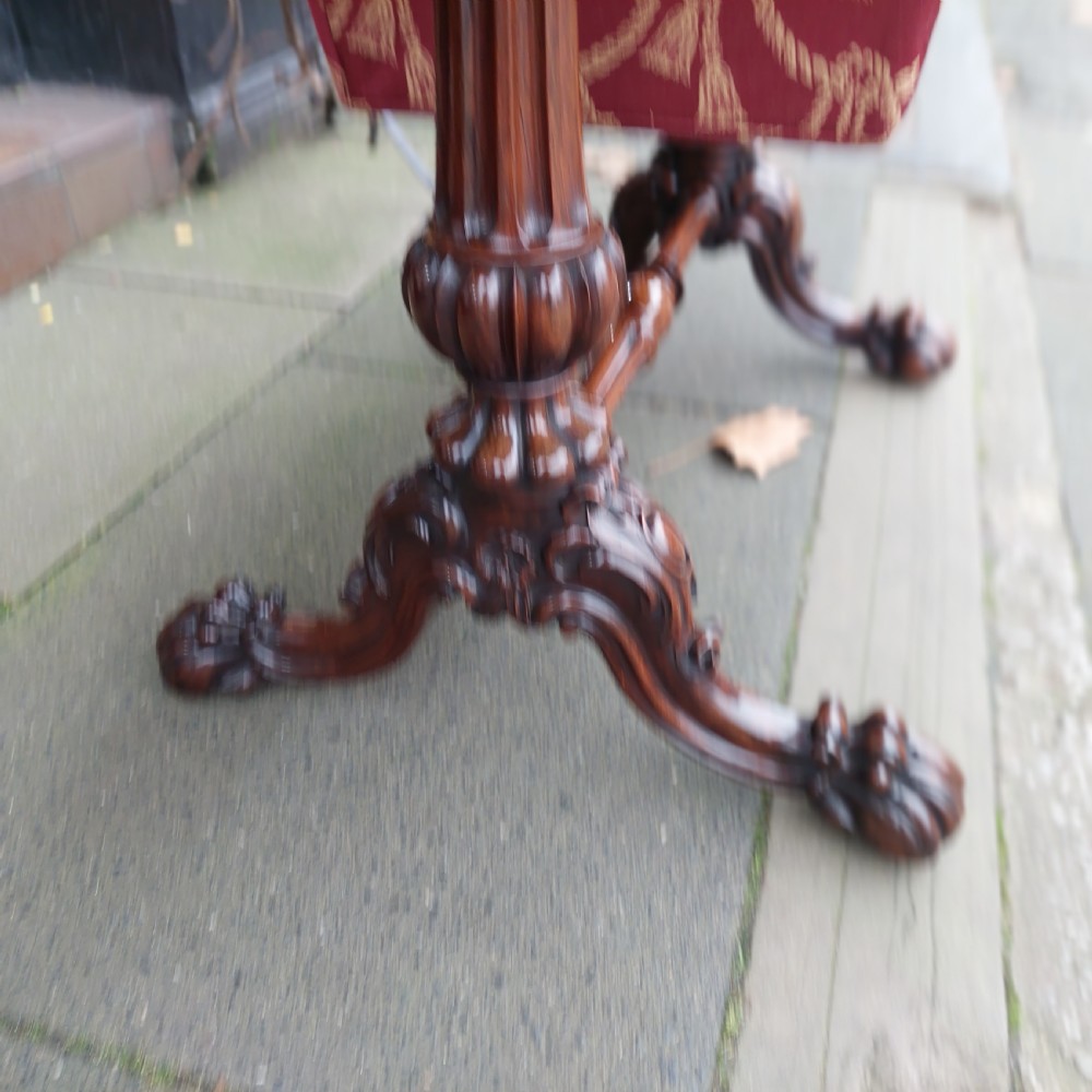 A Regency rosewood work table featuring drop leaves, a single frieze drawer, a red patterned fabric sewing well below, turned pedestal supports, and carved claw feet. View IV