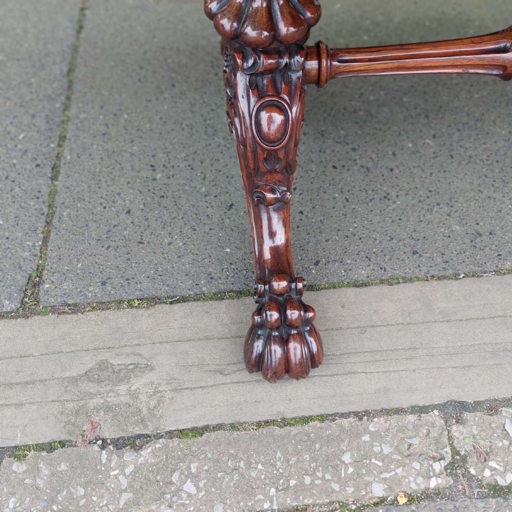 A Regency rosewood work table featuring drop leaves, a single frieze drawer, a red patterned fabric sewing well below, turned pedestal supports, and carved claw feet. View VI