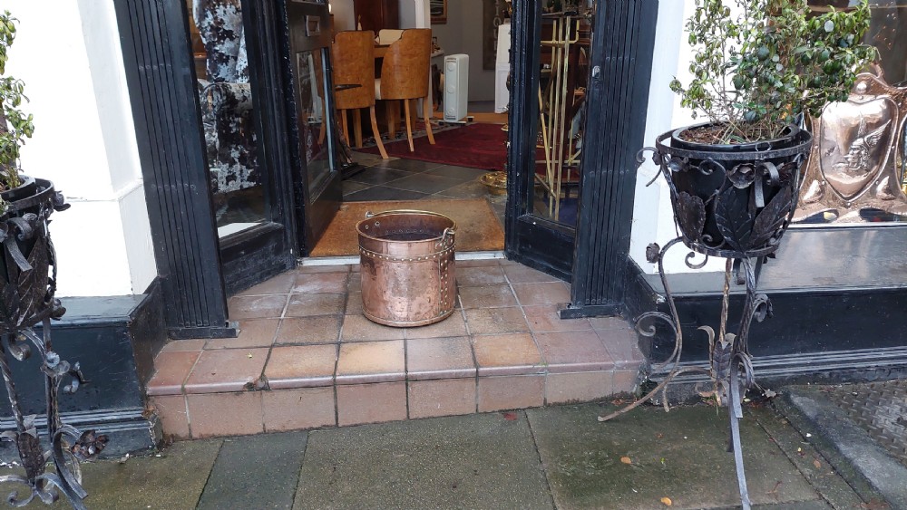 A circular Victorian copper log bucket featuring visible rivet construction along the seams and a brass swing handle. View II