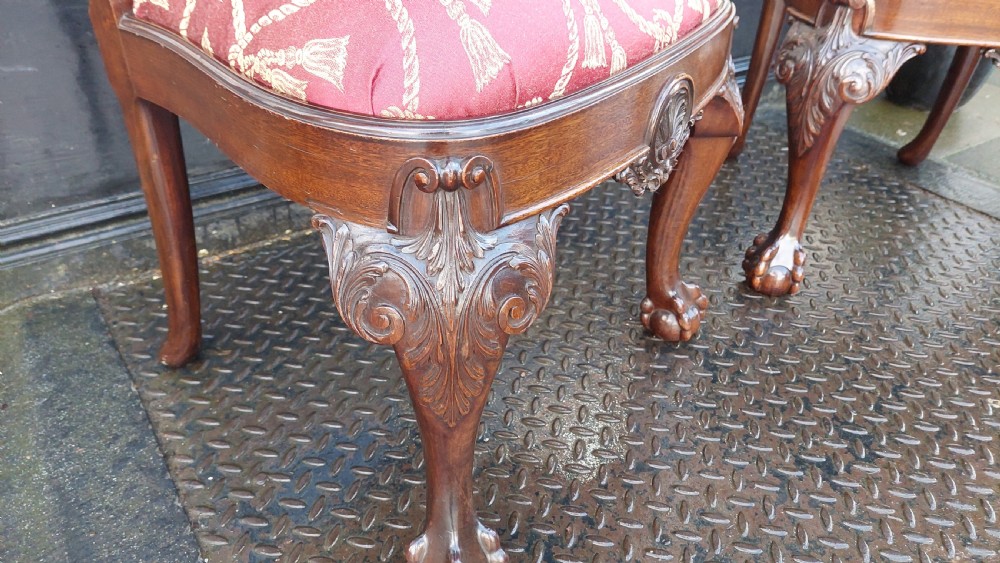 A pair of late 19th-century Queen Anne style carved mahogany side chairs with shell motif crests, splat backs, cabriole legs with claw and ball feet, and red patterned fabric seats. View II
