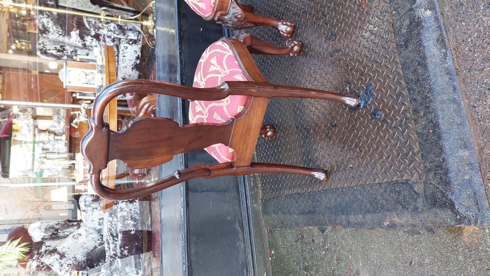 A pair of late 19th-century Queen Anne style carved mahogany side chairs with shell motif crests, splat backs, cabriole legs with claw and ball feet, and red patterned fabric seats. View VI