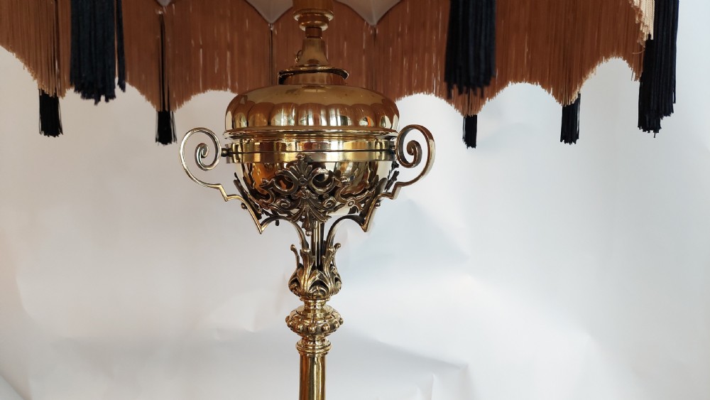 An ornate Victorian brass adjustable standard lamp featuring a scrolled tripod base with paw feet and a fabric shade with fringed tassels. View V