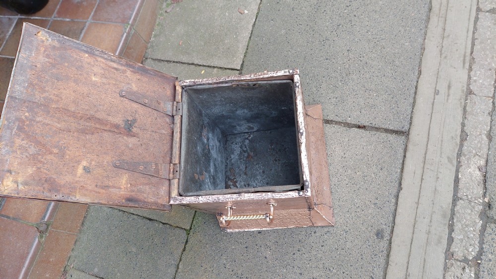 A square hand-hammered copper coal box featuring embossed stylised botanical motifs, riveted metal borders, side handles, and a flared base. View VI