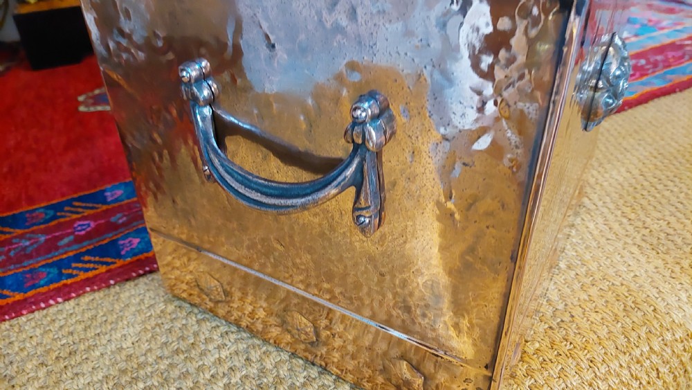 A late 19th-century square copper-plated coal box featuring a hammered finish, hinged lid, drop side handles, and decorative metal studs along the base. View II