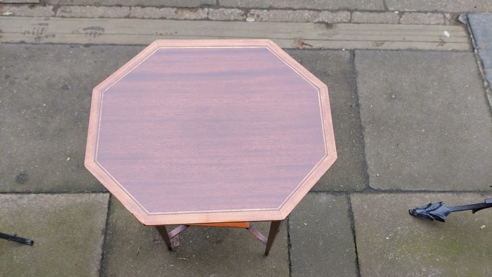 An Edwardian mahogany torchere stand featuring an octagonal top with satinwood inlay, four slender splayed legs, and a square lower undertier. View II
