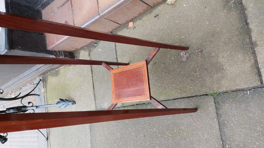 An Edwardian mahogany torchere stand featuring an octagonal top with satinwood inlay, four slender splayed legs, and a square lower undertier. View III